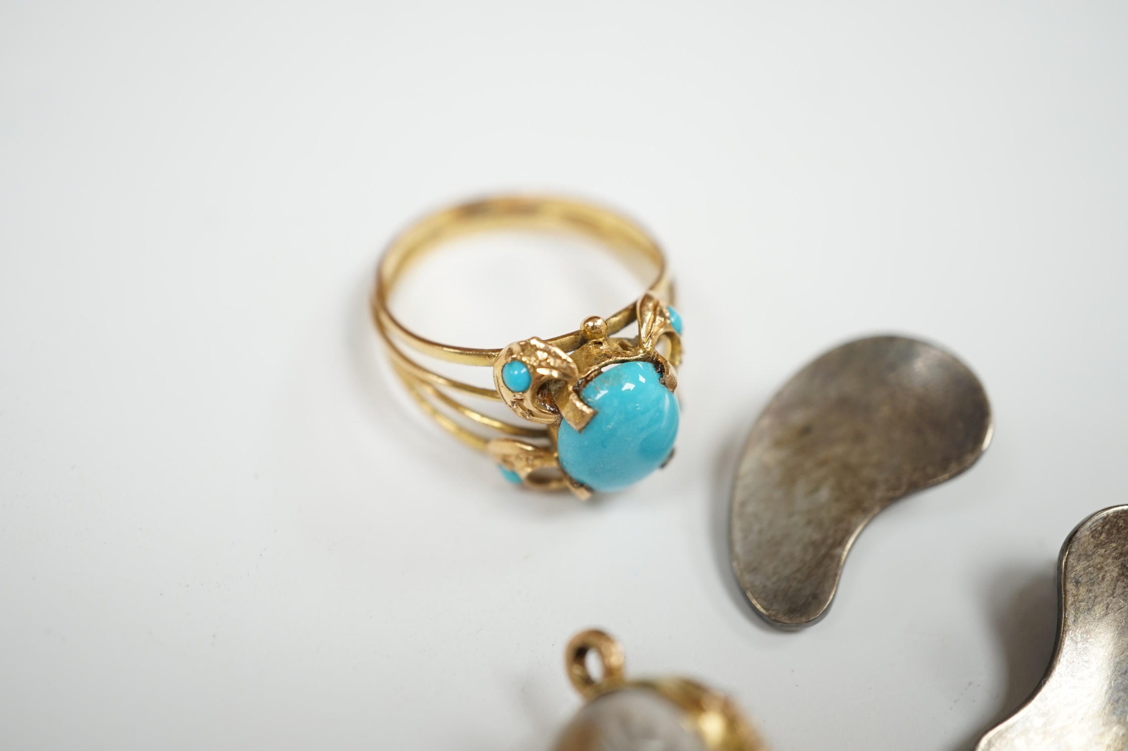A Middle Eastern yellow metal and turquoise cluster set ring, size P/Q, together with a yellow metal and Essex crystal style egg shaped pendant, depicting a flower and a pair of Georg Jensen sterling ear clips, design no